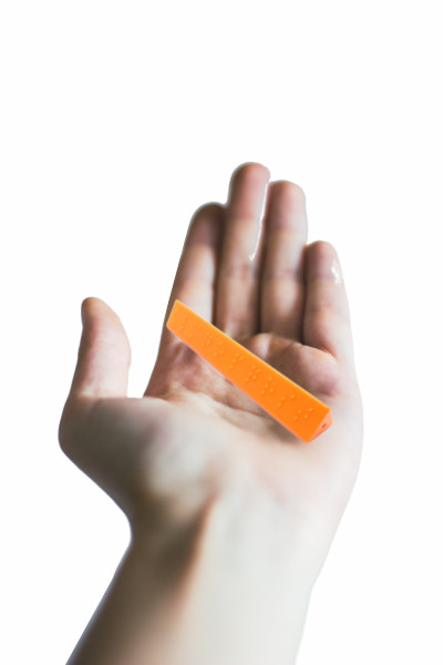 adult hand holding Braille Stick